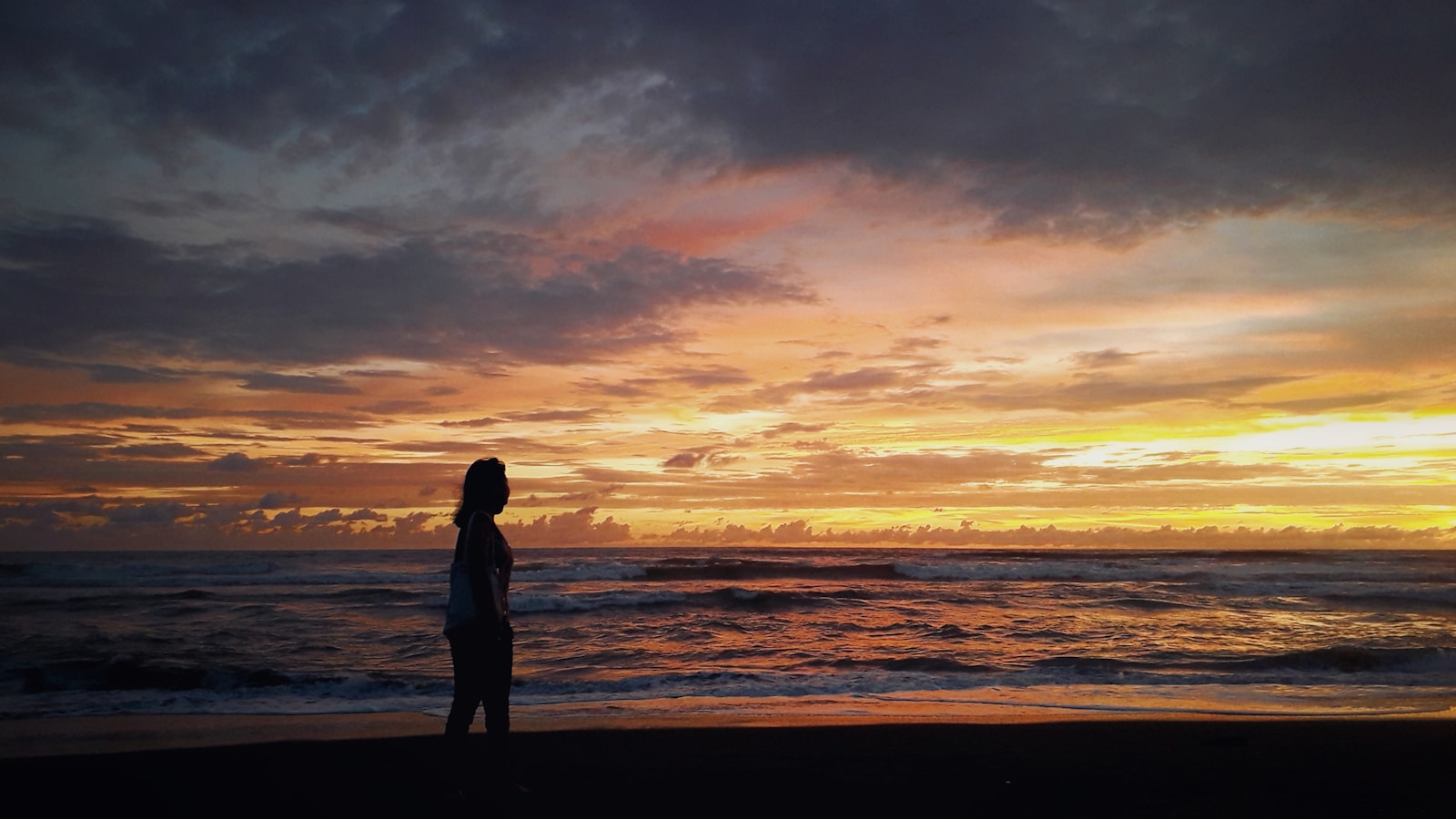 Photo by Ake Widyastomo a person standing on a beach